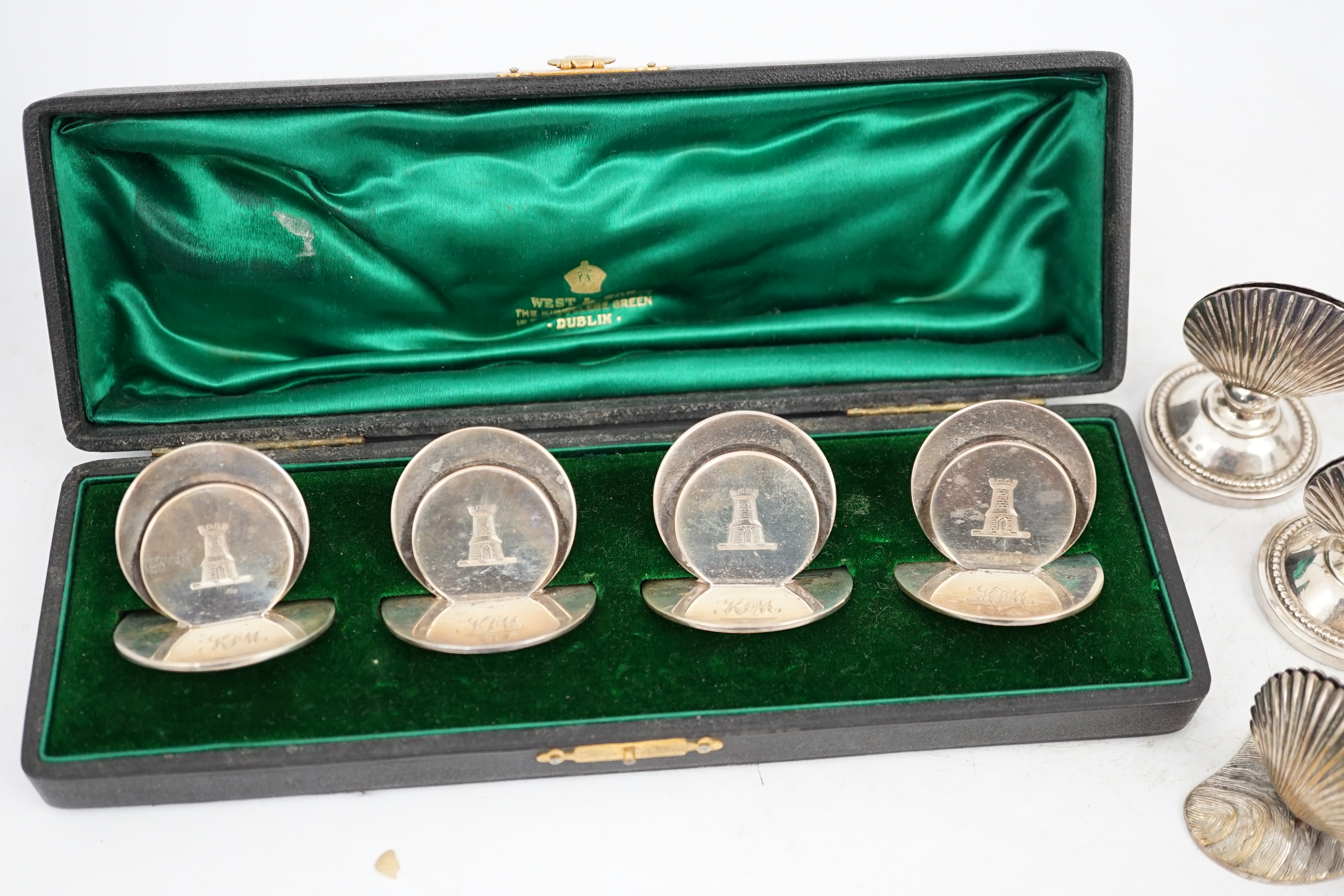 A cased set of four silver menu holders, engraved with castle crest, Sampson Mordan & Co, Chester, 1904, height 37mm, together with eight plated menu holders